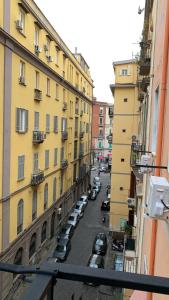 a view of a city street with cars parked between buildings at Borgo Angioino in Naples