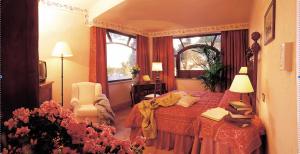 een slaapkamer met een bed, een stoel en een raam bij Hotel La Locanda Dei Ciocca in Grottaferrata