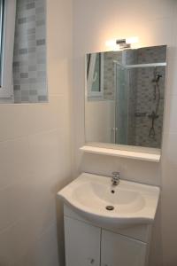 a white bathroom with a sink and a mirror at Gîte altzia haut in Saint-Michel +10 photos
