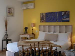 a bedroom with a chess board on a bed at Hotel Les Ambres in Roussillon