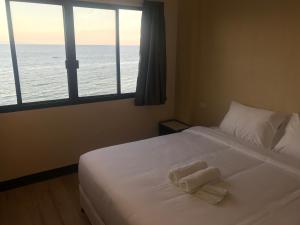 奥斯洛布Babylon Oslob Coast Guesthouse的一间卧室，床上有两条毛巾