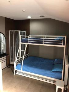 1 dormitorio con 2 literas con sábanas azules en HOSTEL Backpacker SOLOPUENT, en Castiello de Jaca