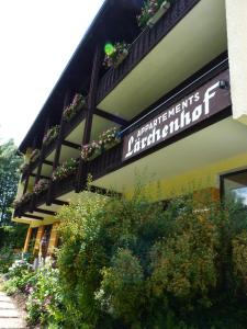 a sign on the side of a building with plants at Appartements Lärchenhof in Bad Kleinkirchheim