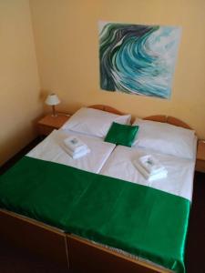 Una cama con dos almohadas verdes y blancas. en Wellness Hotel Jean De Carro en Karlovy Vary
