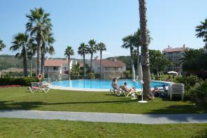 a group of people sitting in chairs by a swimming pool at HG Jardín de Menorca in Son Bou