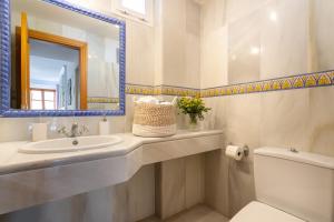 Un baño con lavabo, espejo e inodoro. en Genteel Home Tetuan Marbella, en Marbella 19 fotos más