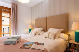 Un dormitorio con una cama con un libro encima. en Genteel Home Tetuan Marbella, en Marbella