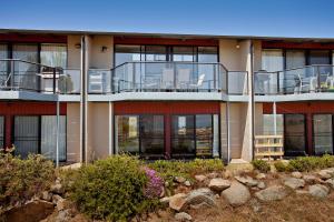 a building with a balcony on the side of it at Stockyards 2, Jindabyne in Jindabyne