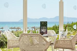 a table and chairs with a view of the ocean at Grupotel Parc Natural & Spa in Playa de Muro