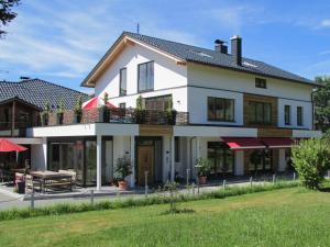 a large white house with a balcony at Pension Waldkristall in Frauenau