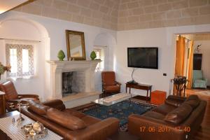 Masseria Fragnale في فاسانو: غرفة معيشة مع أريكة ومدفأة