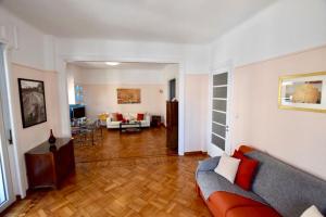 a living room with a couch and a table at Spacious & Sunny Kolonaki Apt 5 mins metro/ACx3/1.5 BT in Athens