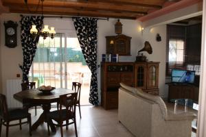 uma sala de estar com uma mesa e cadeiras e um sofá em Villa Costa. em Tossa de Mar