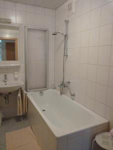 Baño blanco con bañera y lavamanos en Appartements Lärchenhof, en Bad Kleinkirchheim