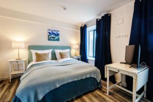ein Schlafzimmer mit einem blauen Bett und einem TV in der Unterkunft FeWo Prora - Hygge in Binz