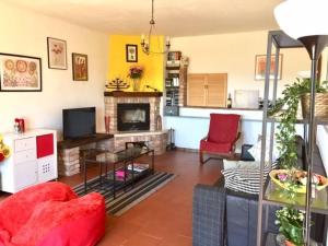 sala de estar con silla roja y chimenea en Large secluded villa, fabulous countryside views, beautiful Piedmonte landscape, en Castelnuovo Belbo