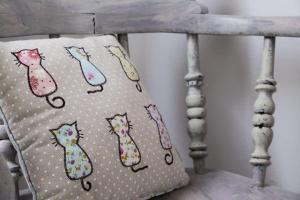 Una almohada con cuatro gatos sentada en una cama en Casa Angiolina - Holidays - Appartamento Dolce Letargo, en Morcote