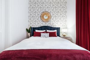 1 dormitorio con 1 cama grande con almohadas rojas en Tomasza 20 Apartments, en Cracovia
