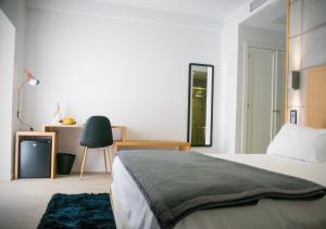 1 dormitorio con cama, escritorio y silla en Hotel EH Piedra Y Luz, en Hinojosa del Duque