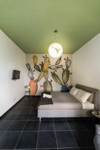1 dormitorio con 1 cama con un mural de aves en WelcHome - guest accomodation, en Enna