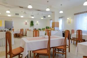 une salle à manger avec des tables et des chaises blanches dans l'établissement Hotel *** NAT Wisła, à Wisła