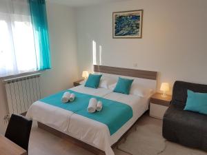 a bedroom with a bed with two slippers on it at Apartment Grašo in Rab