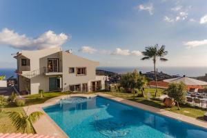 une villa avec une piscine en face d'une maison dans l'établissement OurMadeira - BelAir, fabulous, à Funchal