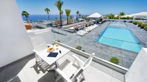 a balcony with a table and chairs and a swimming pool at Ura Lara Adults Only in Puerto Rico de Gran Canaria