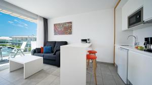 a kitchen and living room with a couch and a table at Ura Lara Adults Only in Puerto Rico de Gran Canaria