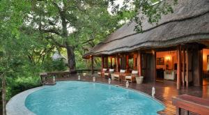 a house with a swimming pool in front of it at Imbali Safari Lodge in Mluwati Concession 