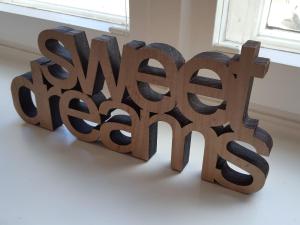 a wooden sculpture of the word art on a table at Apartments Harmsstraße 13 in Kiel