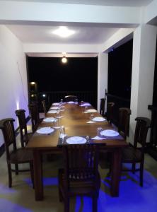 a long wooden table with chairs and plates on it at 4 Aces Ella in Ella