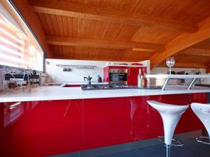 cocina con armarios rojos y encimera blanca en Le Dimore Di Ponte Selce, en Fondi