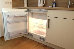 an empty refrigerator with its door open in a kitchen at Easy Stay Apartment in Oberboihingen +4 photos