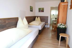 a hotel room with two beds and a table at Easy Stay Apartment in Oberboihingen