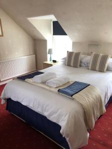 a large hotel room with two beds and a window at Green Tree Hotel in Peebles