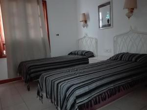 2 Betten in einem Hotelzimmer mit Röcken in der Unterkunft Bungalow Mariano 140 in Playa Honda