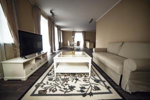a living room with a couch and a tv at Royal Sauna Apartments in Klaipėda