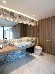 a bathroom with a tub and a toilet and a mirror at 台南圈旅 in Tainan