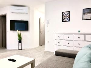 a living room with a tv and a white dresser at Guest house Kobal in Zgornje Gorje