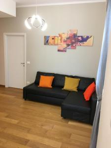 a living room with a black couch with colorful pillows at Cooper Apartment in Genoa
