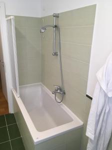 a bath tub in a bathroom with a shower at Cooper Apartment in Genoa
