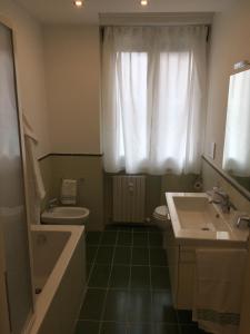 a bathroom with a sink and a tub and a toilet at Cooper Apartment in Genoa