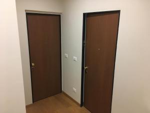 two brown doors in a room with wooden floors at Cooper Apartment in Genoa