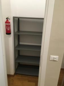 a black book shelf in a room with a fire extinguisher at Cooper Apartment in Genoa
