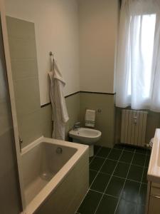 a bathroom with a tub and a toilet and a sink at Cooper Apartment in Genoa