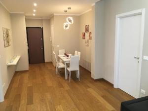 a dining room with a table and white chairs at Cooper Apartment in Genoa