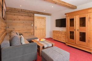 a living room with a couch and a tv at Bauernhof Mühltalhof in Ellmau