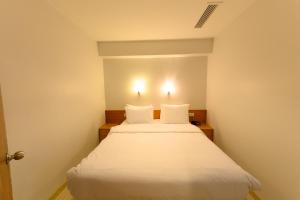 1 dormitorio con 1 cama blanca y 2 almohadas en Entes Apart, en Estambul