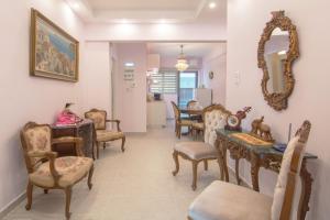 sala de estar con sillas, mesa y espejo en Lovely Apartment in Athens, en Atenas